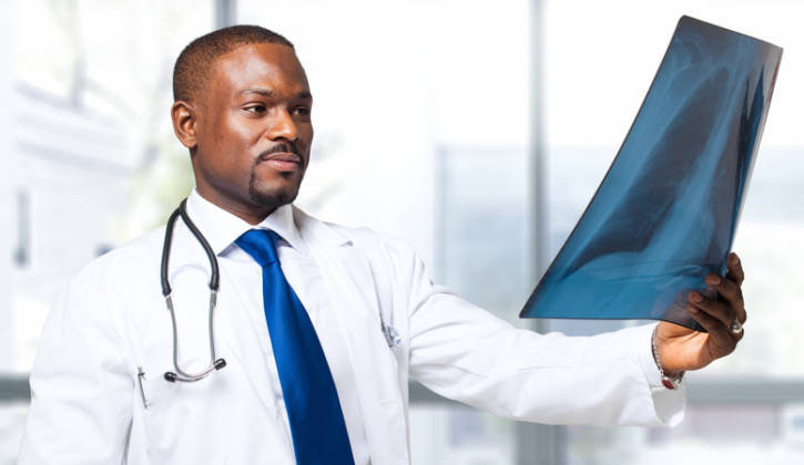 African American doctor looking at lung x-ray