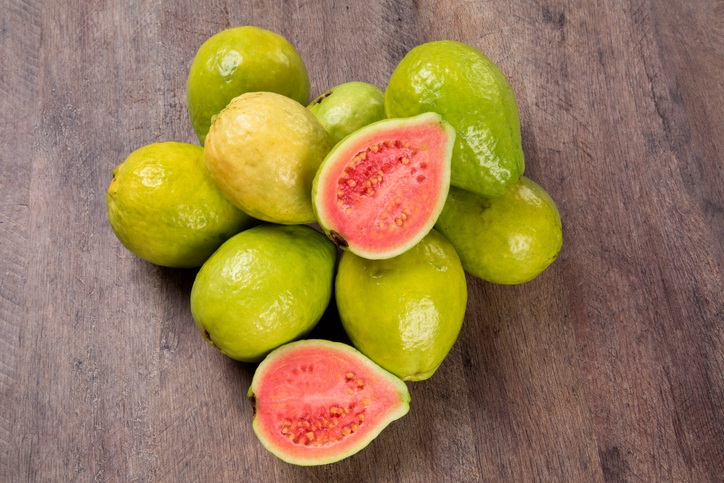 Some brazilian guavas over a wooden surface. Fresh fruits.