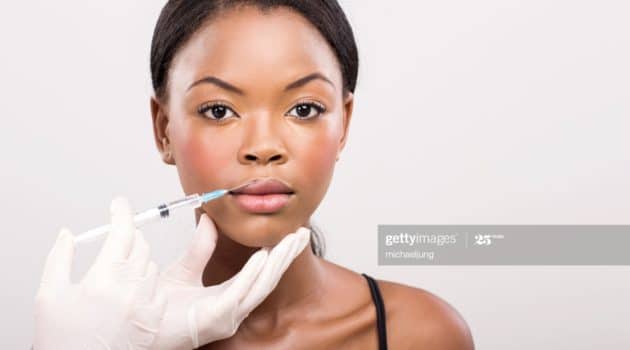 pretty african girl receiving cosmetic injection on her lips
