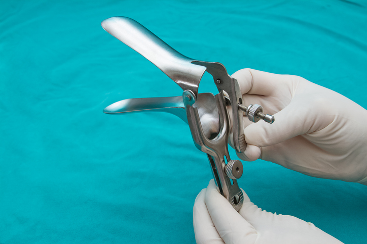 doctor holds a disposable speculum in his hand.