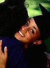 african american woman graduate hugging another woman