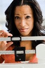 african american woman looking sad while standing on a scale