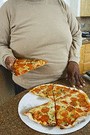 obese man eating whole pizza