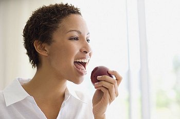 A woman eating a red apple