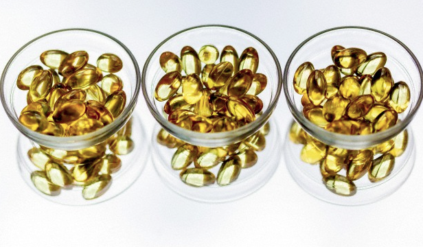 Three small glass bowls filled with omega-3 supplements