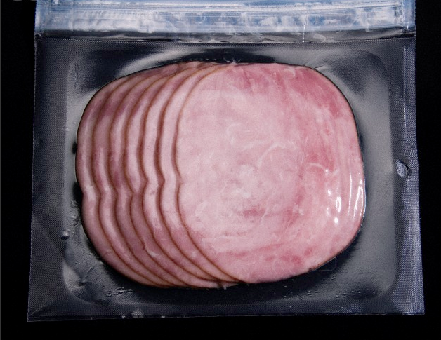 A plastic package filled with sliced ham