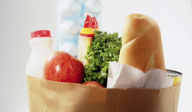 A close-up of a brown paper bag filled with groceries