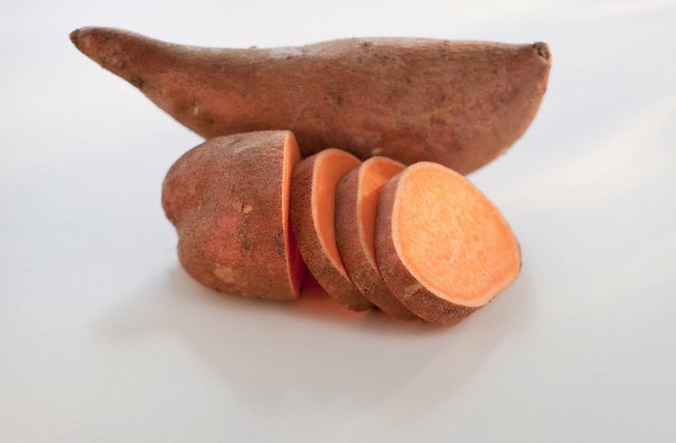 One whole and one sliced sweet potato