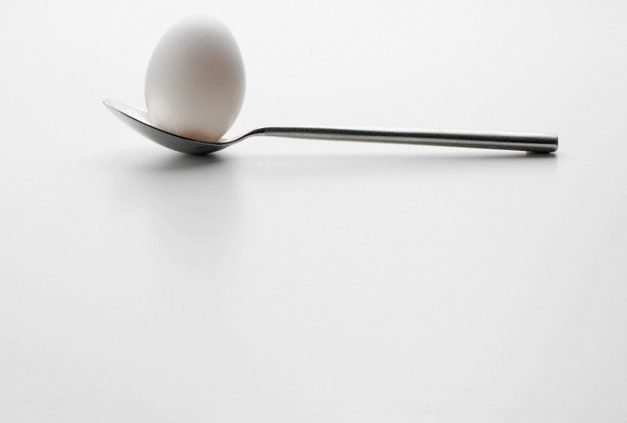 A spoon with an egg balanced in it