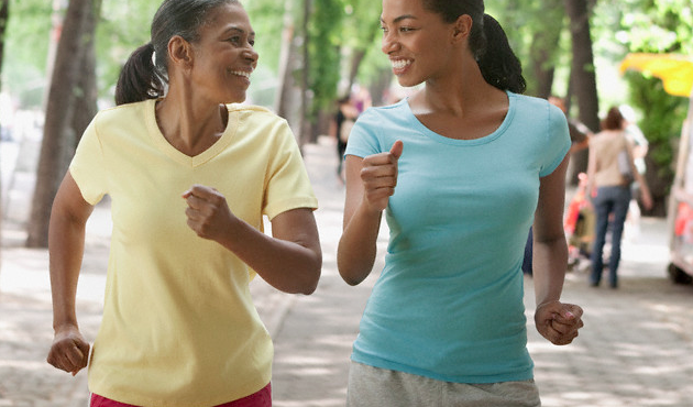 A mother and her adult daughter speed walking together in a park