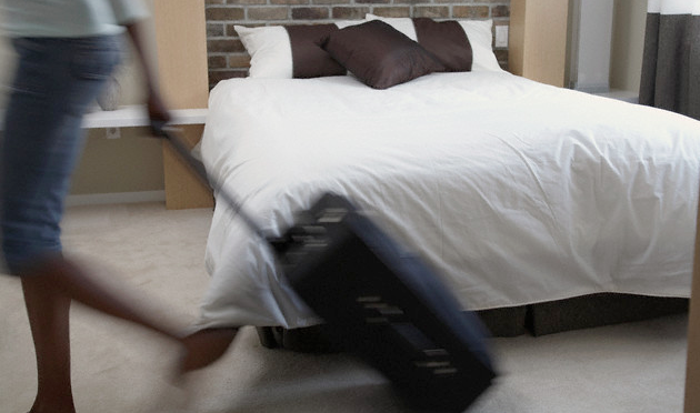 A woman walking quickly with her suitcase
