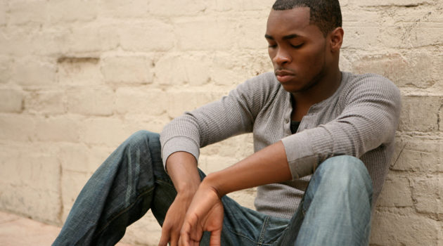 young african american man sitting with head