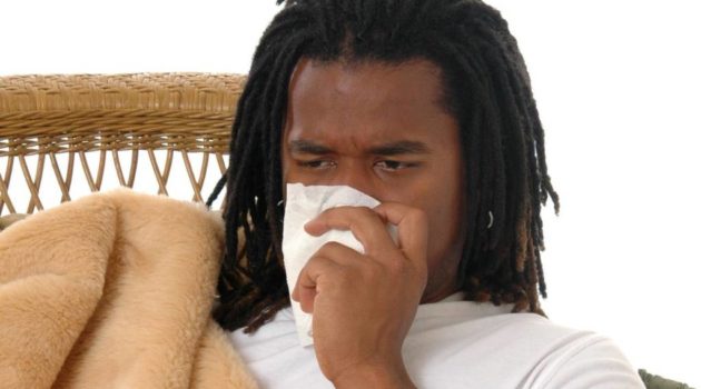 young black man blowing nose