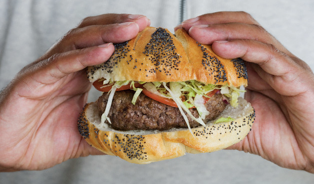 A man's hands holding a burger