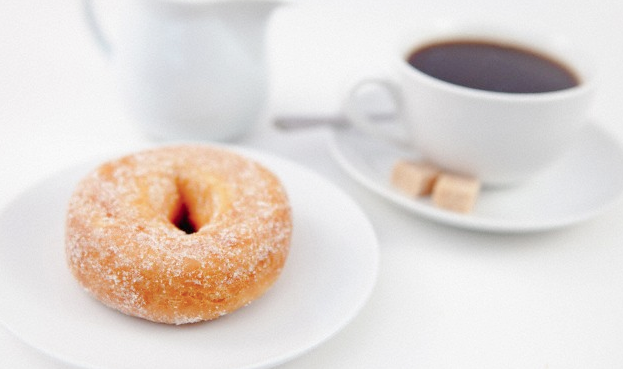 A cup of coffee and a doughnut on a plate