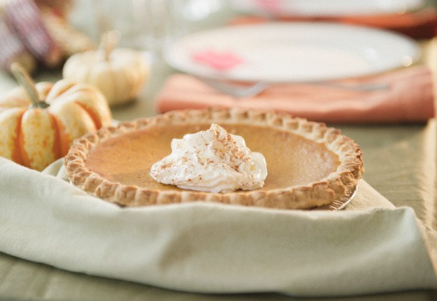 A pumpkin pie on a dining table