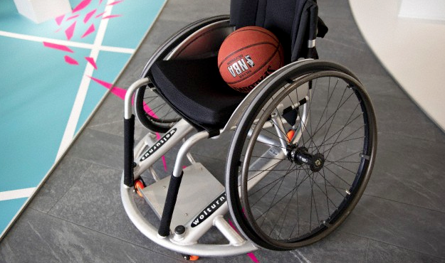 A basketball sitting in the seat of a wheelchair