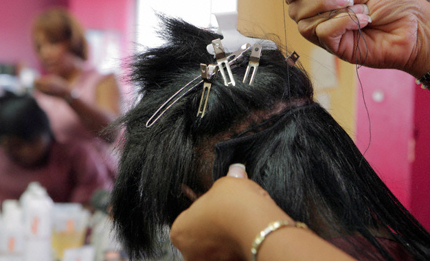 A woman getting her hair weaved 