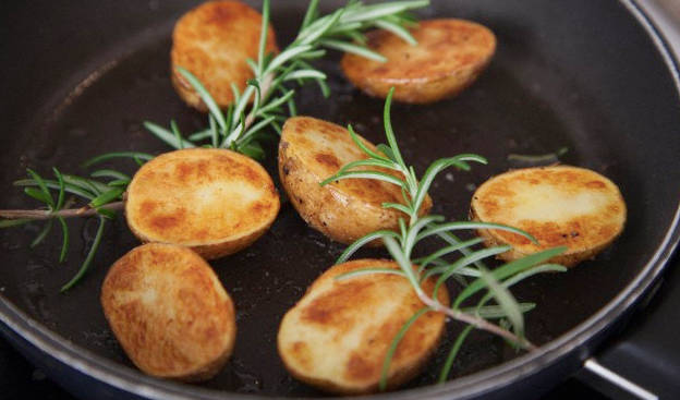 Roasted potato slices with rosemary in a skillet