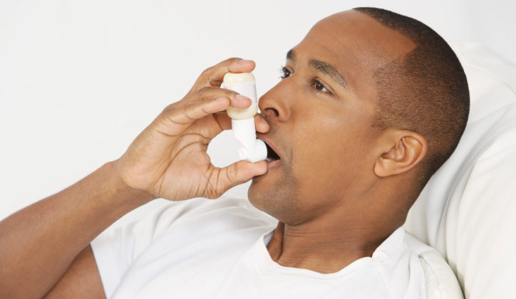 Man using inhaler in hospital bed