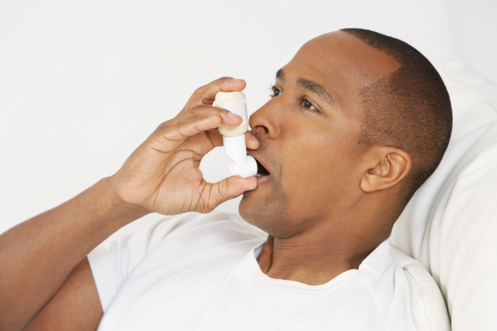 Man using inhaler in hospital bed