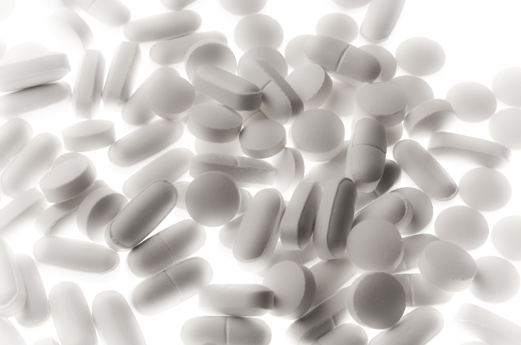Different types of over the counter pain pills scattered on a surface