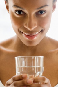 african american woman holding glass of water