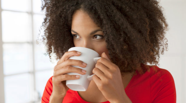 close up of attractive young woman drinking coffee