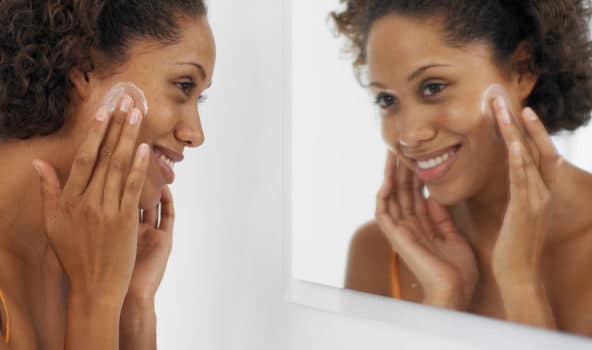 side view of woman applying facial cream