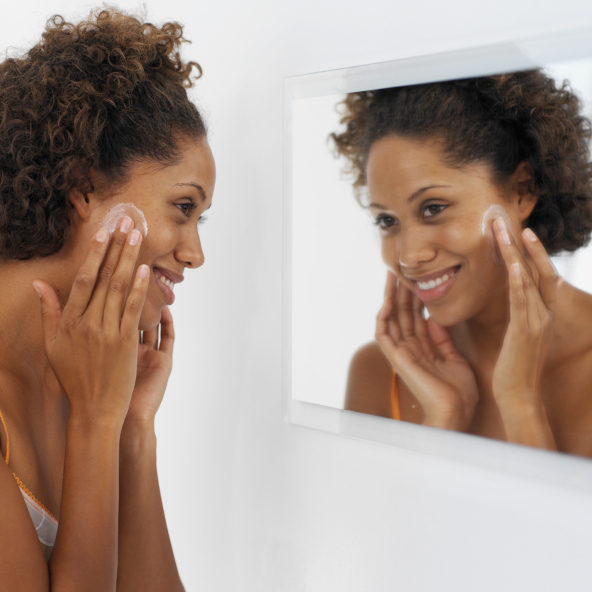 side view of woman applying facial cream