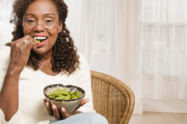 mature woman eating edamame