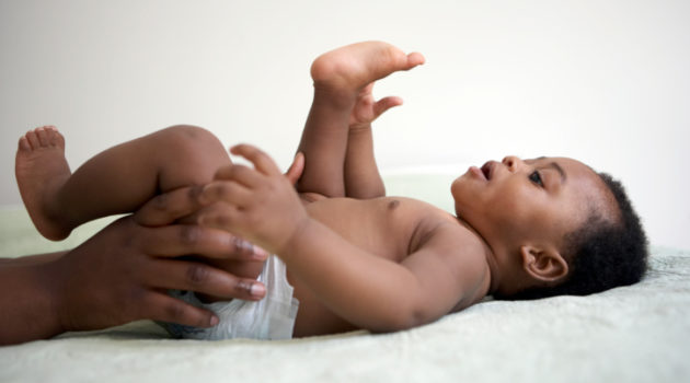 baby lying down looking at his toes