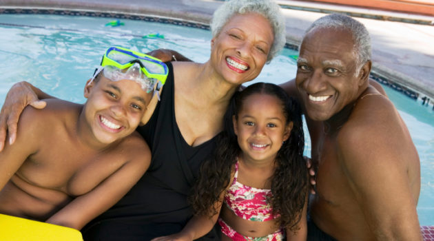 grandparents and grandchildren posing by swimming area