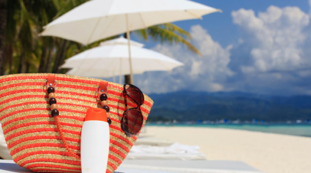 bag, sun glasses and suncream on tropical beach
