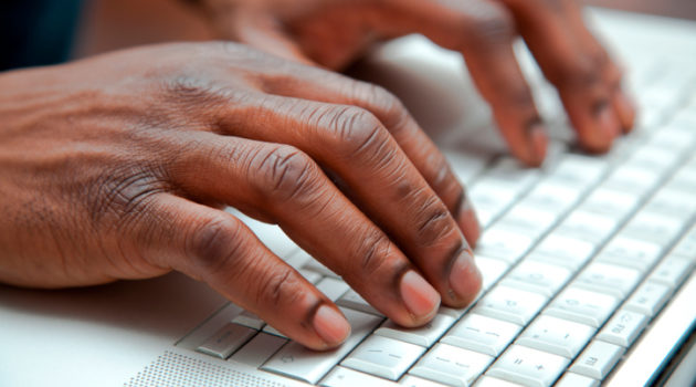 Close up of black hands on a keyboard