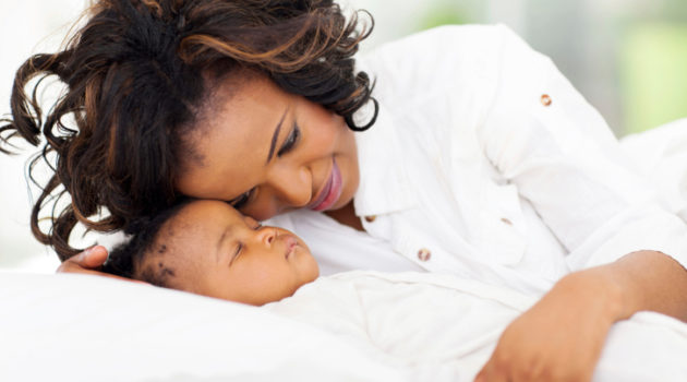 african american mother looking at her sleeping baby