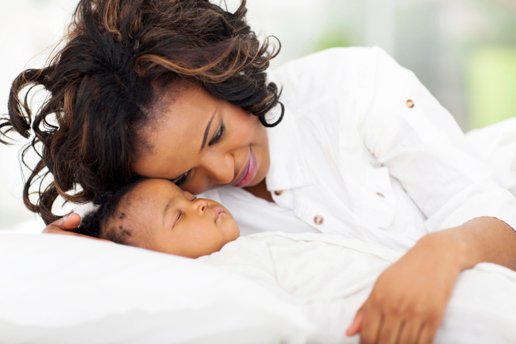 african american mother looking at her sleeping baby