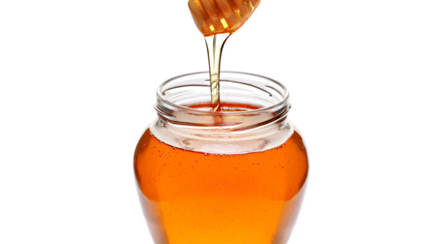 jar of honey with wooden drizzler