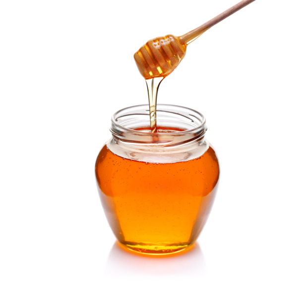 jar of honey with wooden drizzler