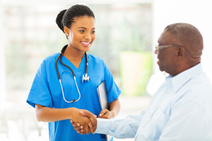 african american medical nurse handshaking with senior patient