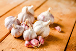 Raw garlic on wooden background