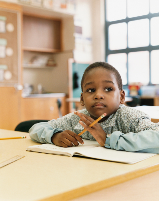 African American Black child sitting at classroom desk