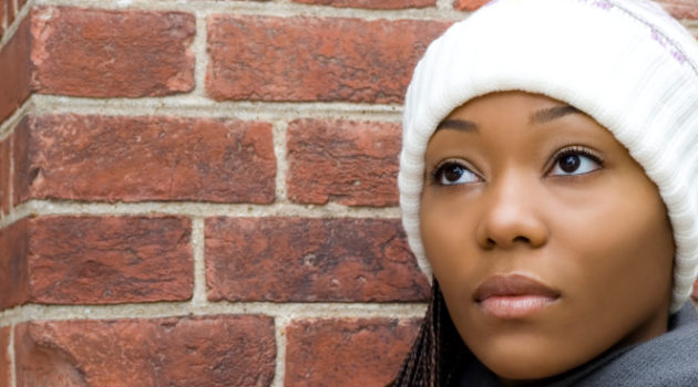 young african american woman wearing a knit hat and looking off into the distance