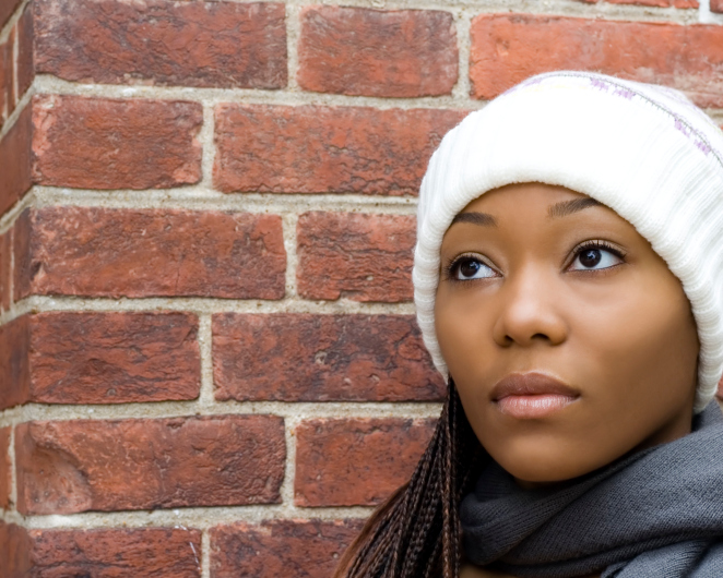 young african american woman wearing a knit hat and looking off into the distance