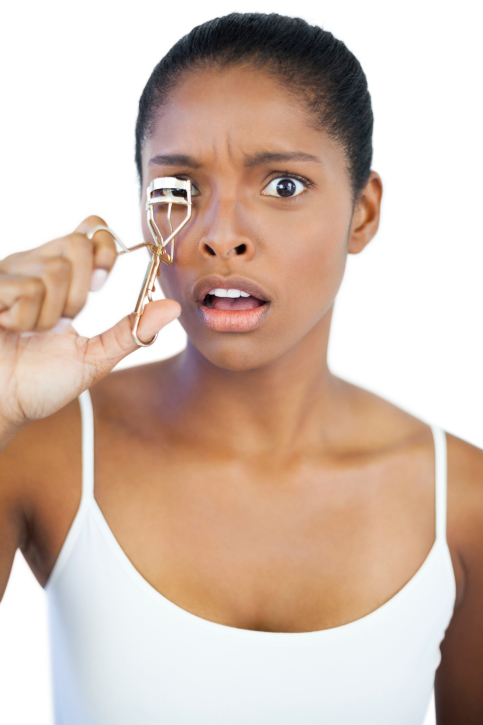 woman using eyelash curler