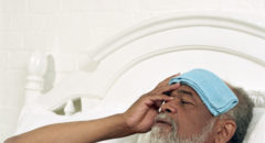 older man with wet towel on his head