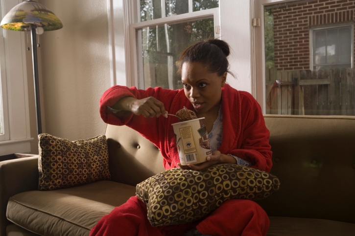 woman on couch eating ice cream