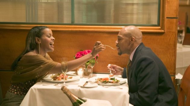 african american woman feeding african american man in a restaurant