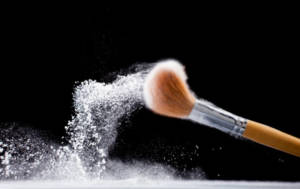 makeup brush dusted in a powder