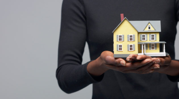 woman holding miniature house